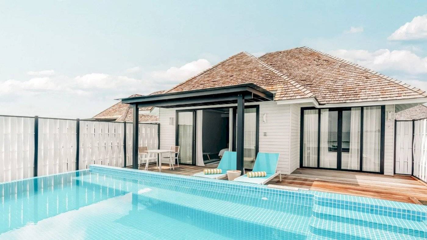 Ein Swimmingpool und eine Villa im Hotel Nova Maldives.