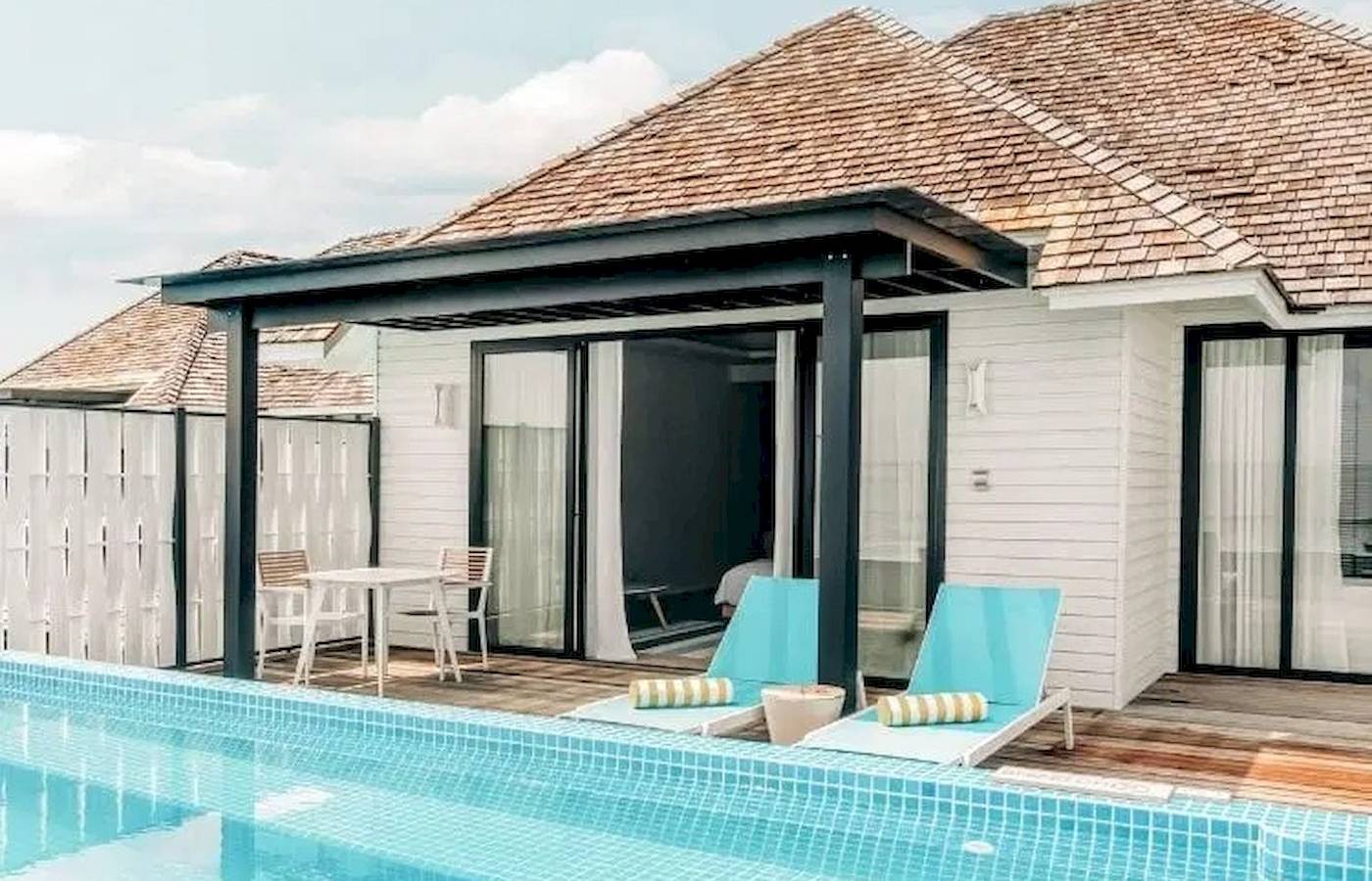 Außenbereich des Nova Maldives Hotels mit Pool und Lounge-Bereich.