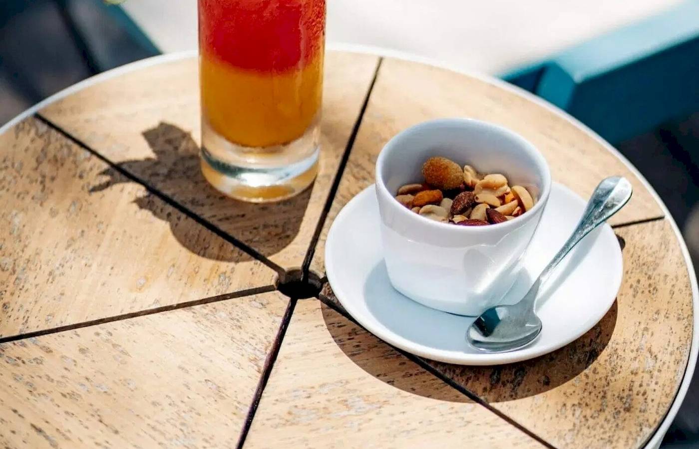 Cocktail auf einem Tisch im Nova Maldives Hotel mit einer Sonnenbrille und einem Hut im Hintergrund.