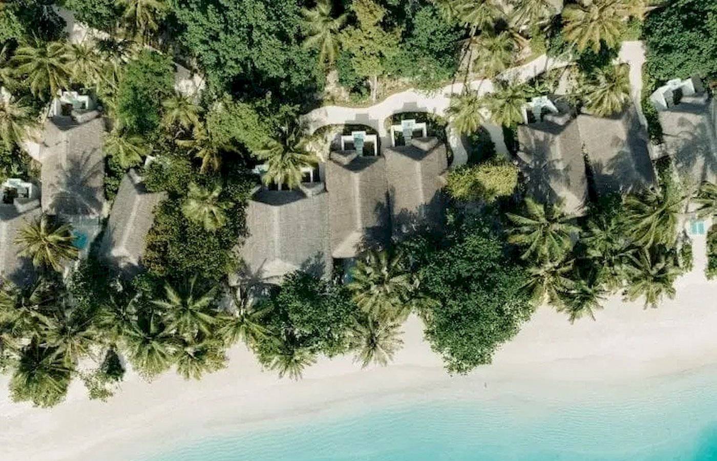 Obersflächlicher Blick auf das Nova Maldives Hotel mit weißen Stränden und blauem Wasser.