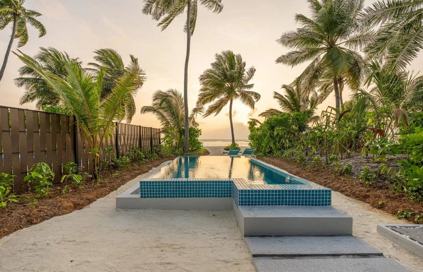 Außenpool des Nova Maldives Hotels bei Sonnenuntergang