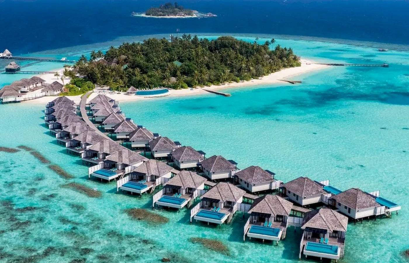Luftaufnahme des Nova Maldives Resorts mit Wasservillen und türkisfarbenem Ozean