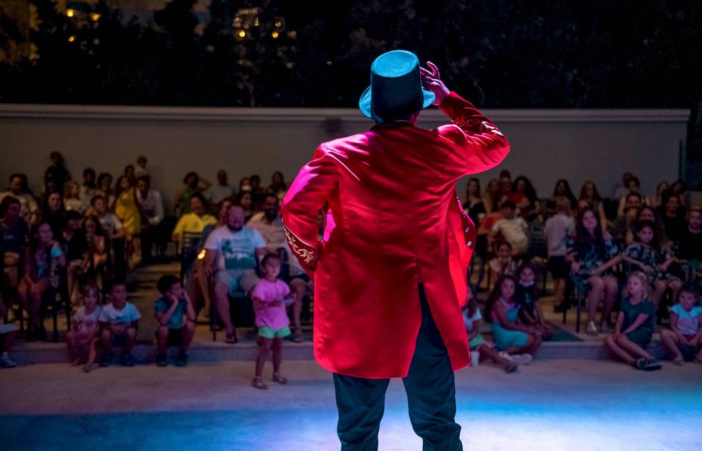 Magier in rotem Mantel und Hut führt eine Show im Mitsis Selection Rinela Hotel vor einem Publikum vor.