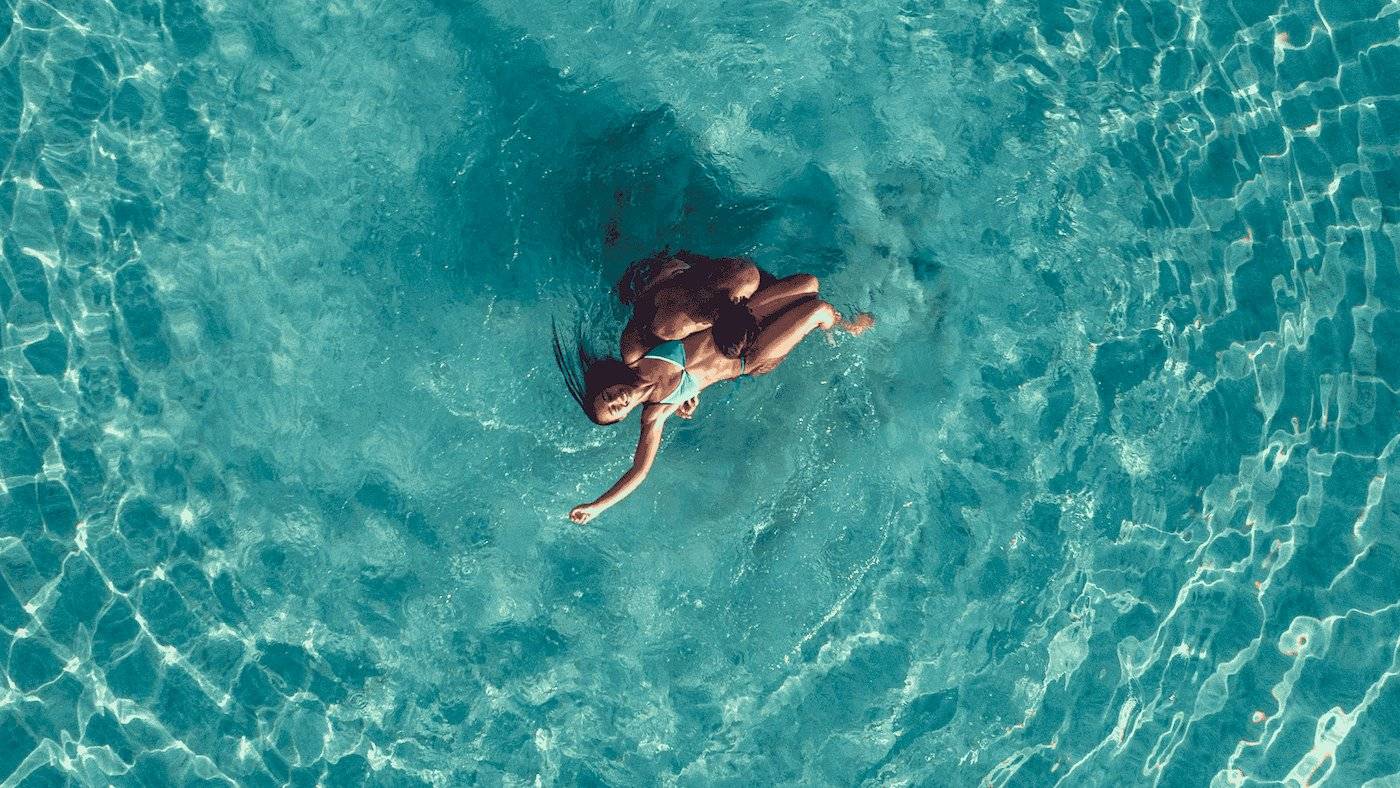 Zwei Frauen schwimmen im Pool des Mitsis Selection Rinela Hotels.