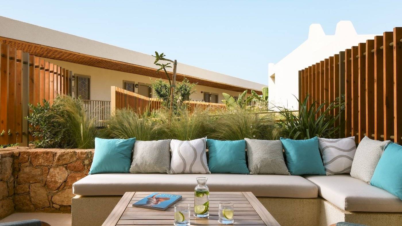 Außenbereich des Mitsis Selection Rinela Hotels mit einer Terrasse und einem Tisch.