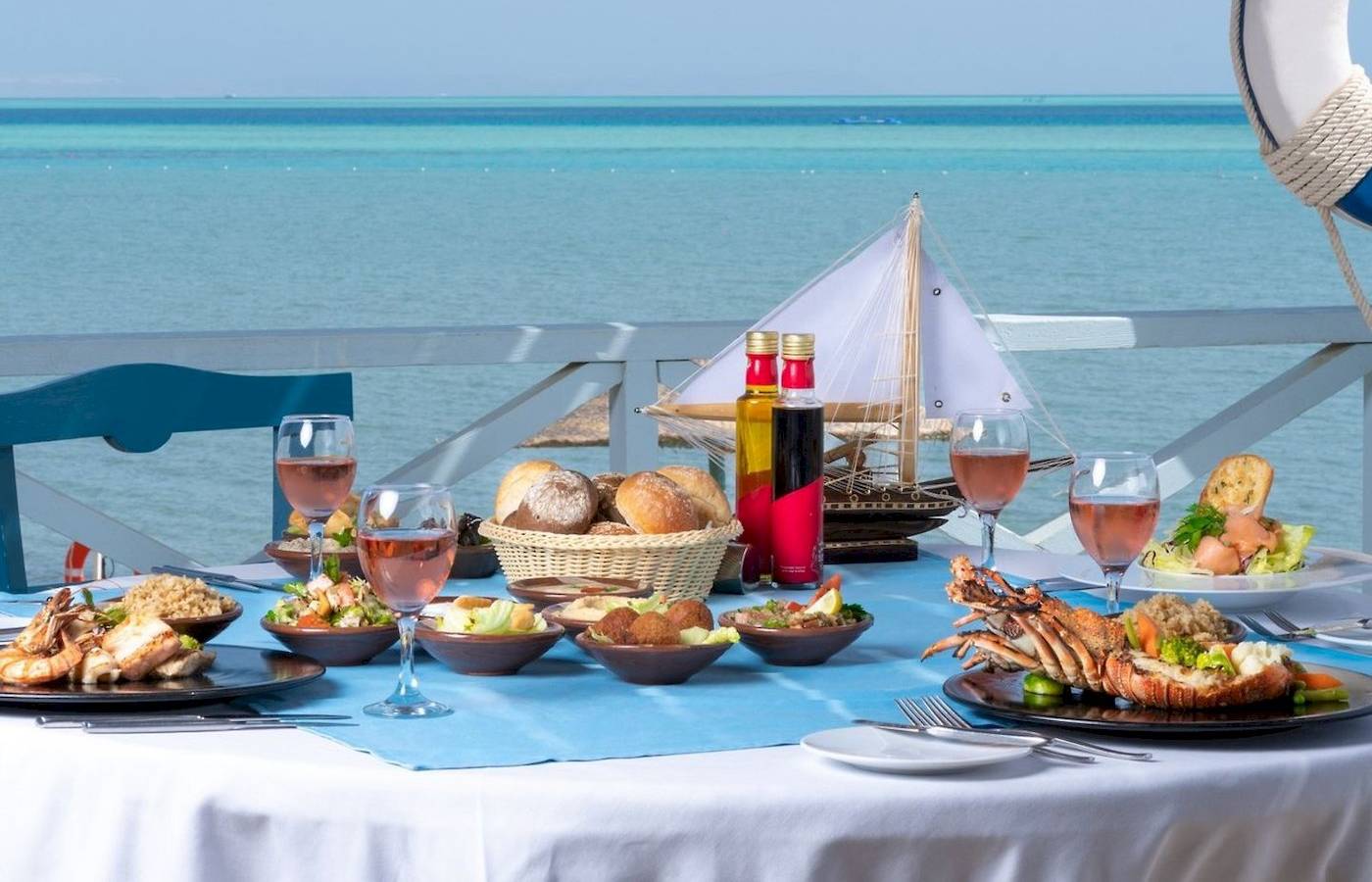 Meerblick-Tisch im Mövenpick Resort & Spa El Gouna mit vielen Gerichten, Gläsern und Dekoration.