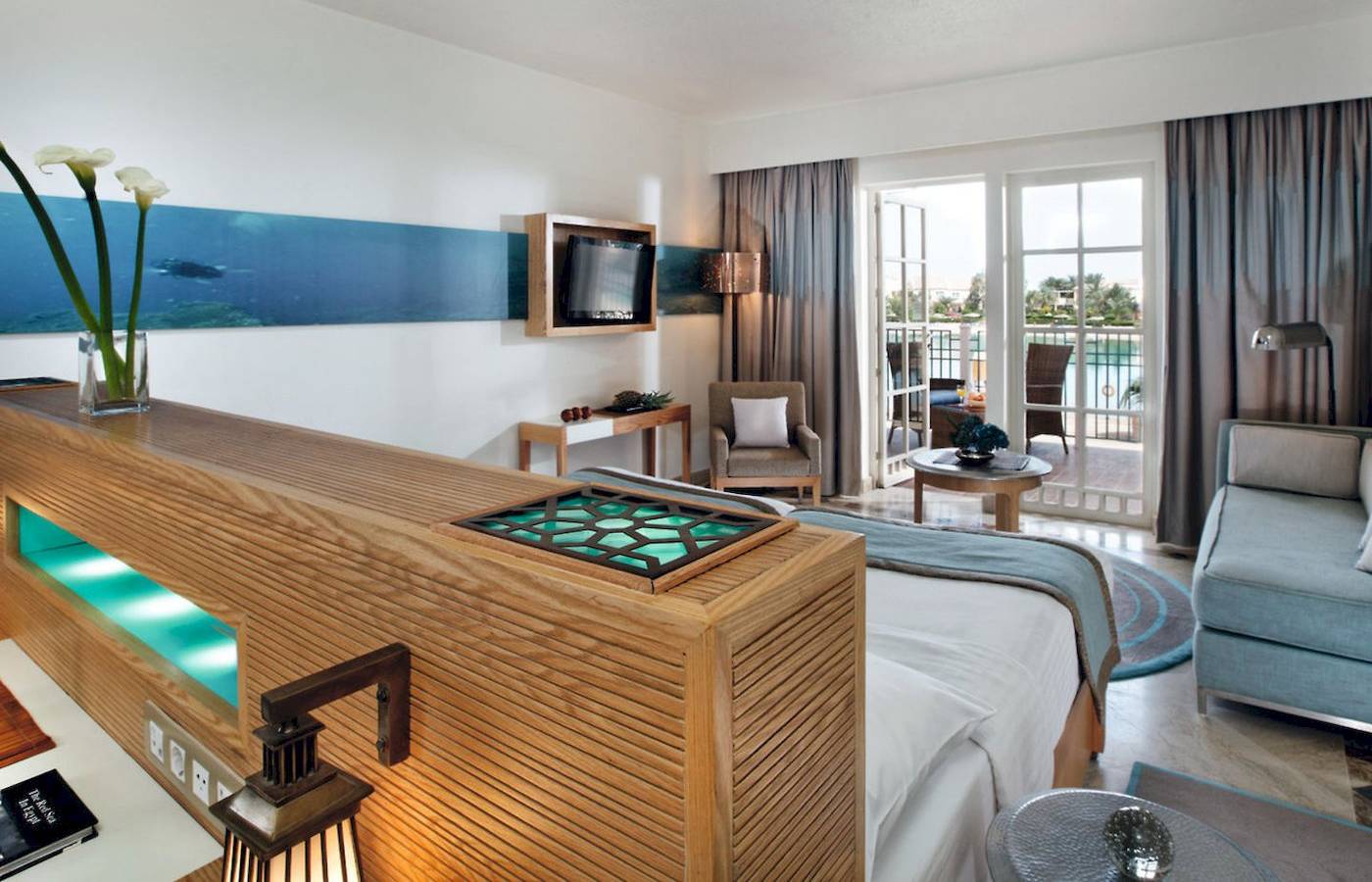 Innenansicht eines Hotelzimmers im Mövenpick Resort & Spa El Gouna mit Bett, Sofa und Meerblick