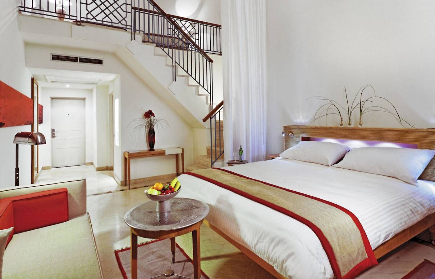 Interieur des Moevenpick Resort & Spa El Gouna mit einem Bett, Früchteschale und Treppe