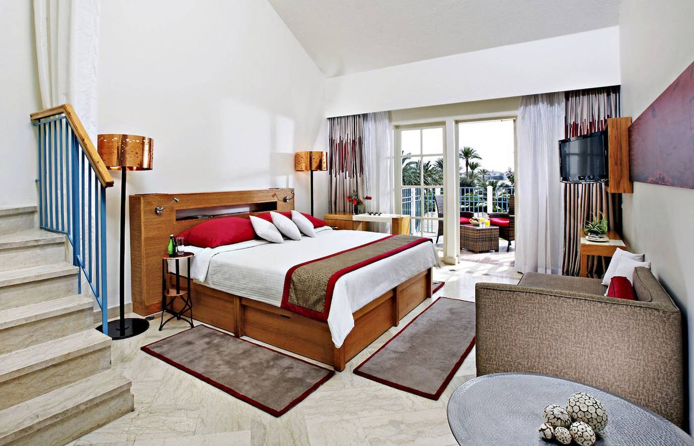 Hotelzimmer im Mövenpick Resort & Spa El Gouna mit Bett, Sofa, Tisch und Balkon