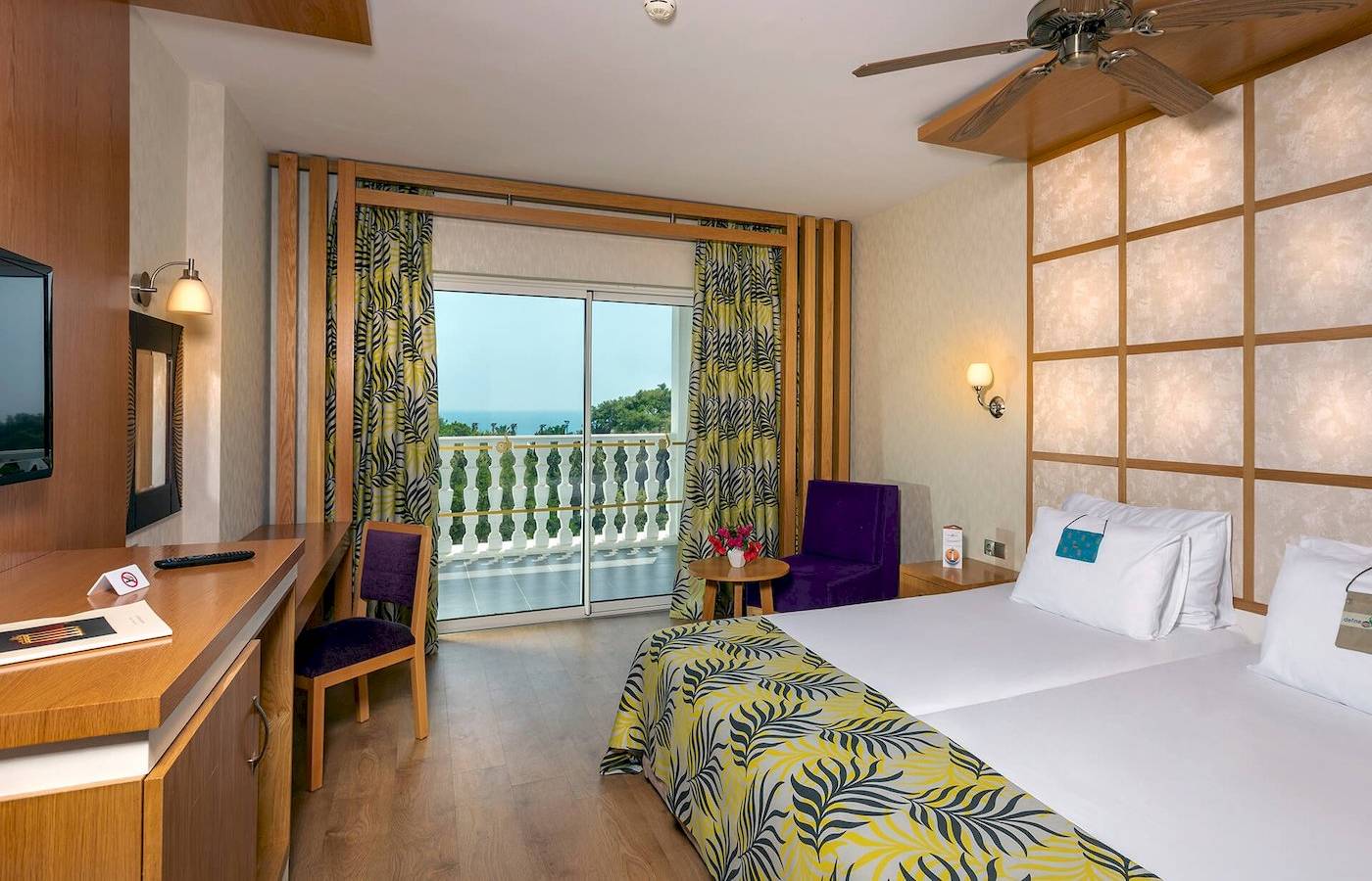 Zimmer im Defne Defnem Hotel mit Blick auf den Balkon und das Meer.