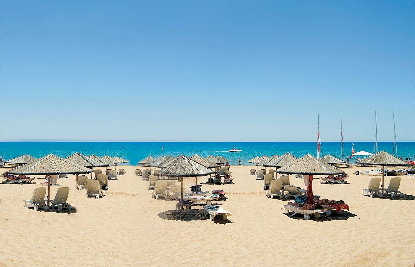 Strand mit vielen Sonnenschirmen und Liegen am Defne Defnem Hotel