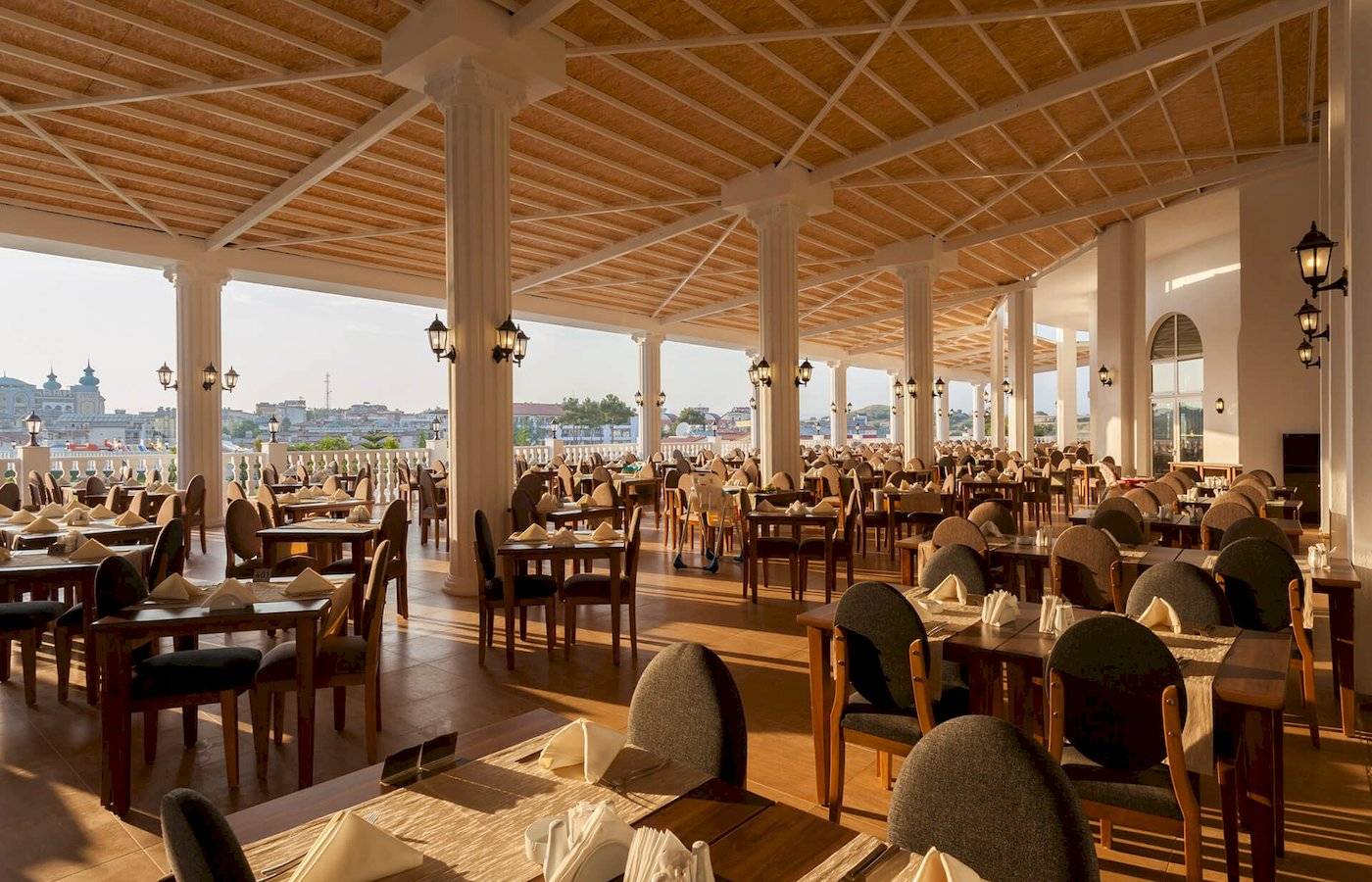 Innenansicht des Restaurants im Defne Defnem Hotel mit vielen gedeckten Tischen und Blick auf die Stadt.