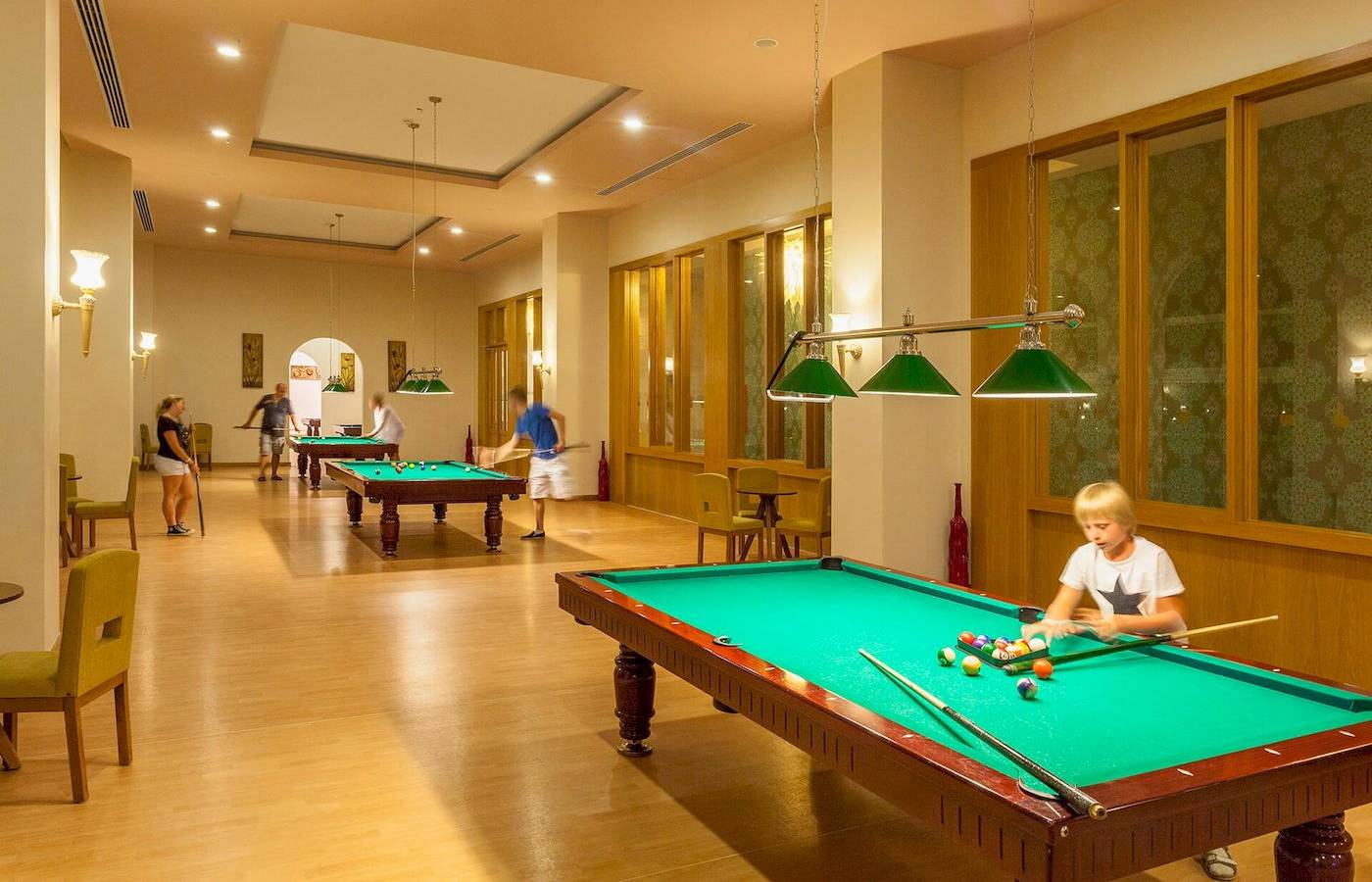 Billardtisch im Defne Defnem Hotel mit mehreren Spielern und Besuchern.