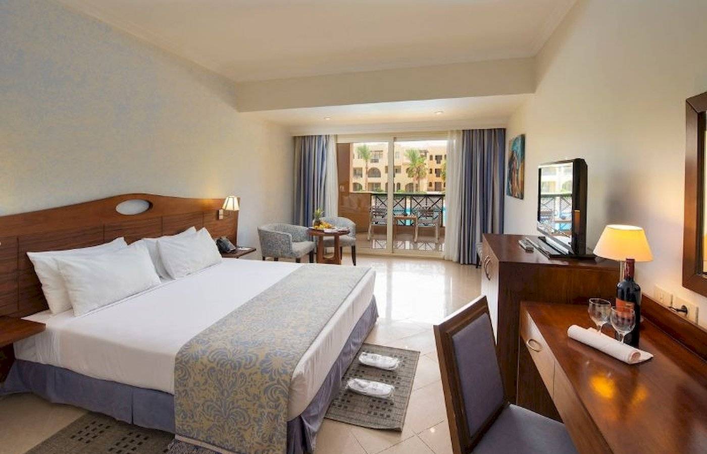 Doppelzimmer im Stella Gardens Resort & Spa Makadi Bay mit Balkon, Bett, Schreibtisch, Fernseher und Balkonzugang
