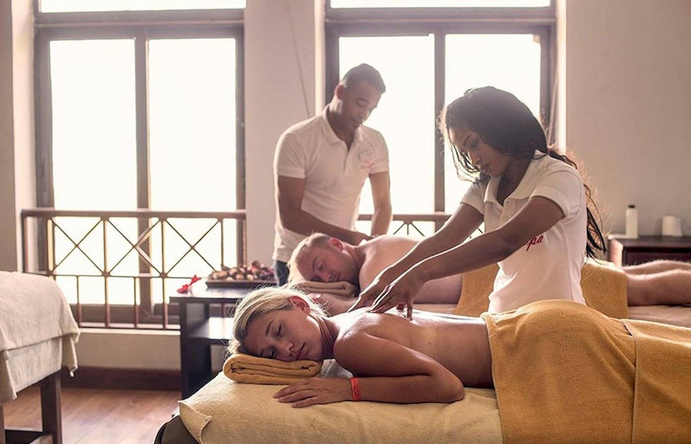 Massagebehandlung im Stella Gardens Resort & Spa Makadi Bay mit einer Frau, die eine Massage an einer Frau durchführt.