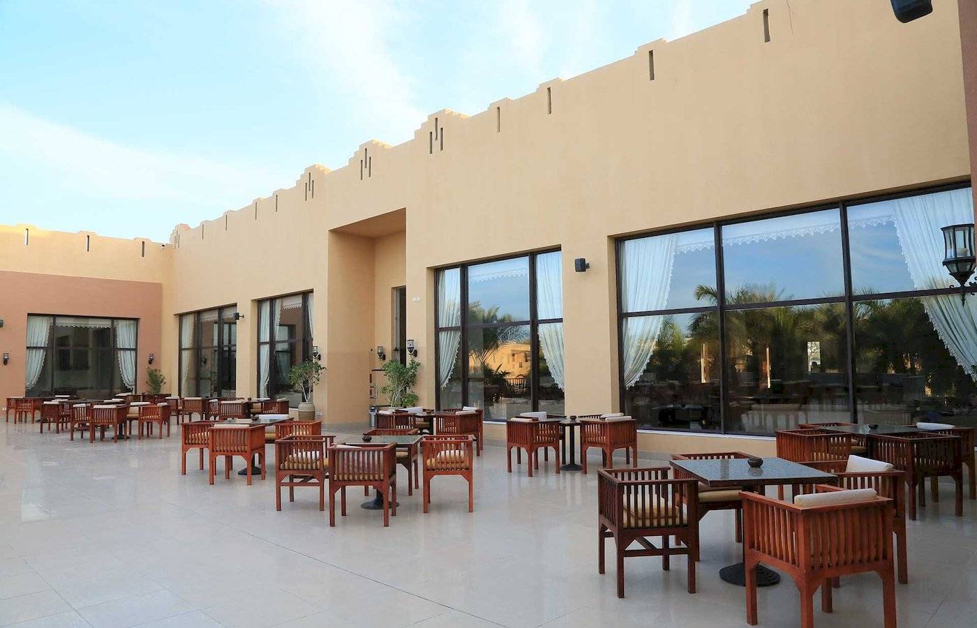 Terrasse mit Tischen und Stühlen im Stella Gardens Resort & Spa Makadi Bay