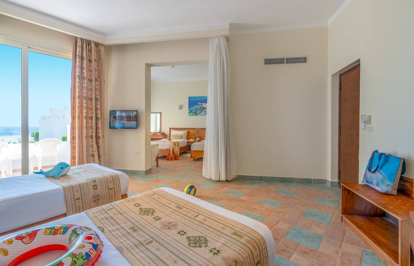 Zimmer im Three Corners Equinox Beach Resort mit zwei Betten, Fernseher und Meerblick.