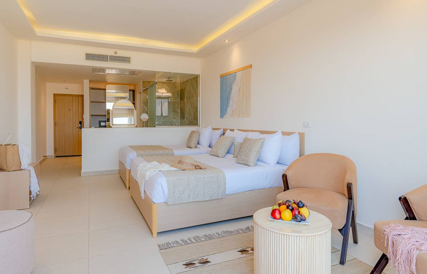 Doppelzimmer im Three Corners Equinox Beach Resort mit zwei Betten und Obsttablett