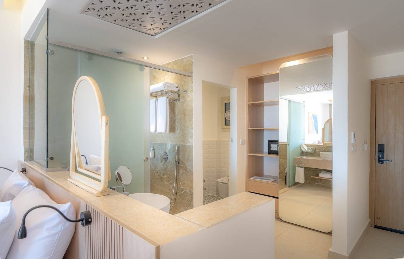Badezimmer im Three Corners Equinox Beach Resort Hotel mit Glasdusche, Spiegel, Toilette und Waschbecken.