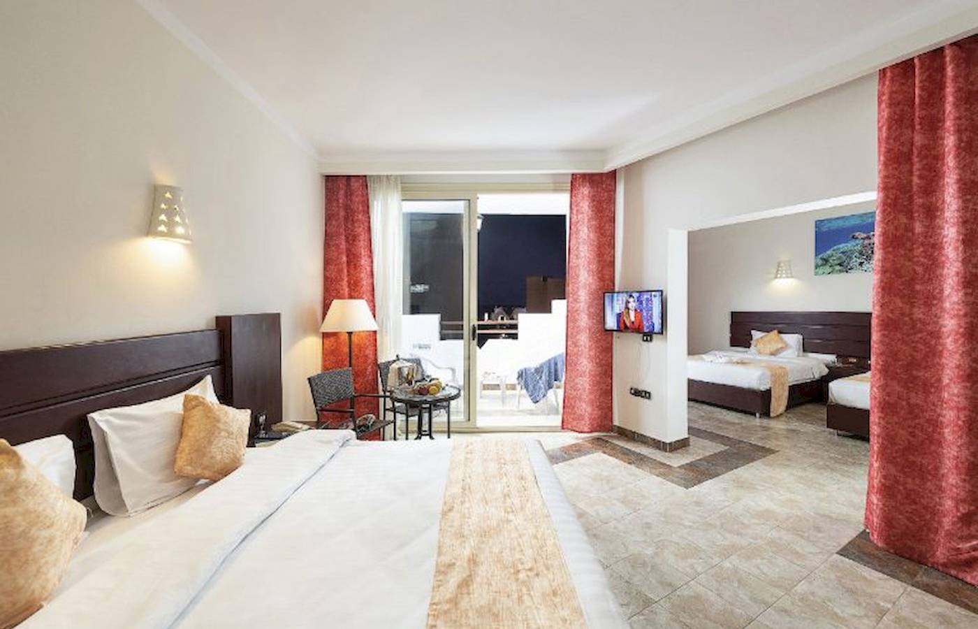 Hotelzimmer im Three Corners Equinox Beach Resort mit Doppelbett, Fernseher und Balkon