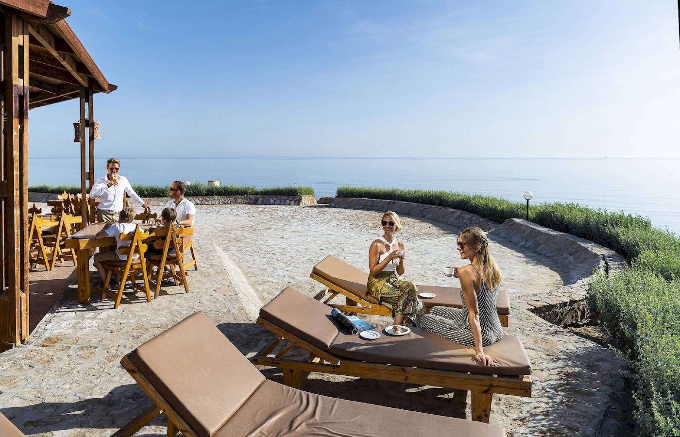 Gäste des Three Corners Equinox Beach Resorts auf einer Terrasse mit Blick auf das Meer.