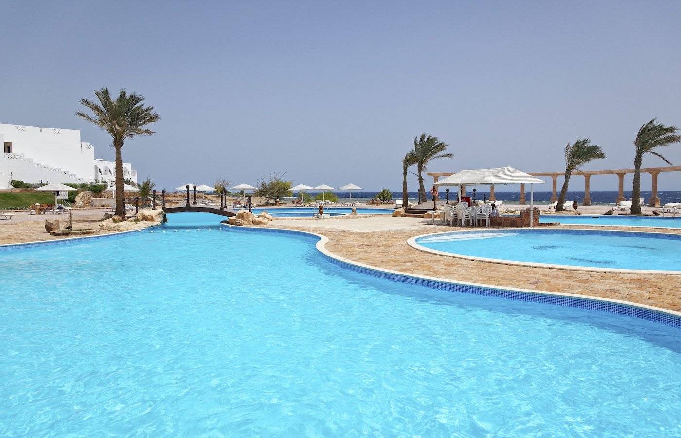 Außenpools des Three Corners Equinox Beach Resort mit Palmen und Sonnenschirmen
