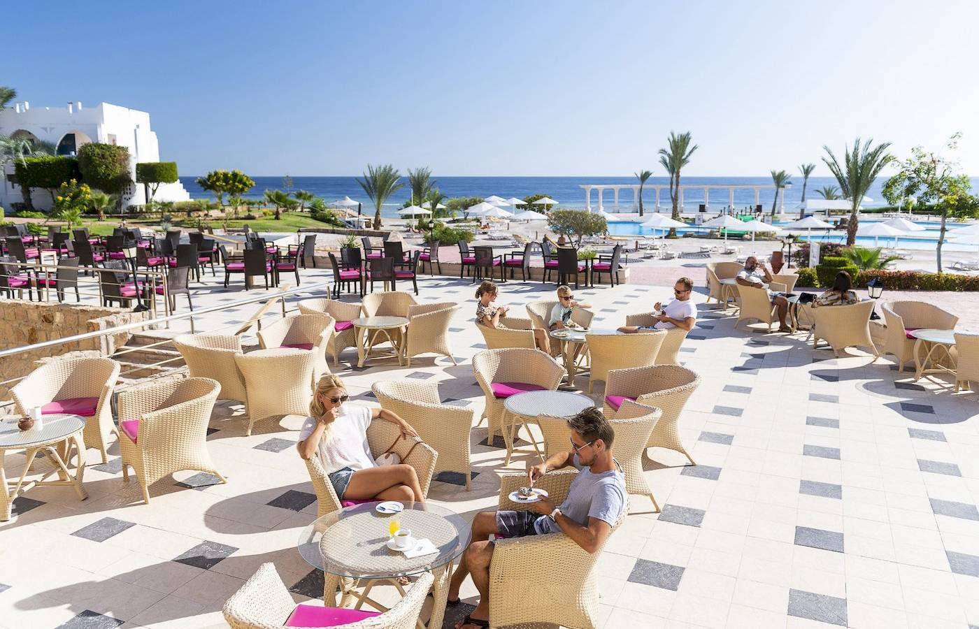 Gäste sitzen auf der Terrasse des Three Corners Equinox Beach Resorts.