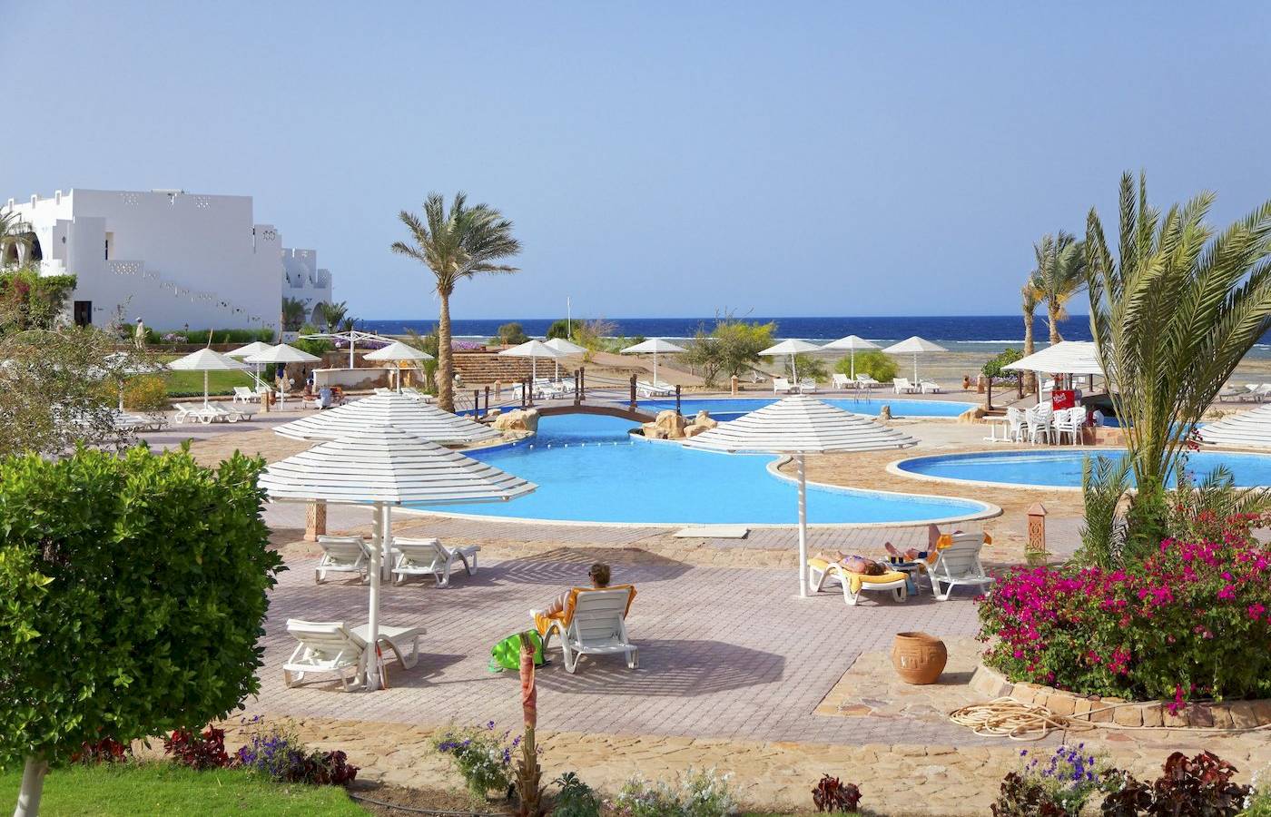 Außenpools mit Sonnenliegen und Sonnenschirmen im Three Corners Equinox Beach Resort