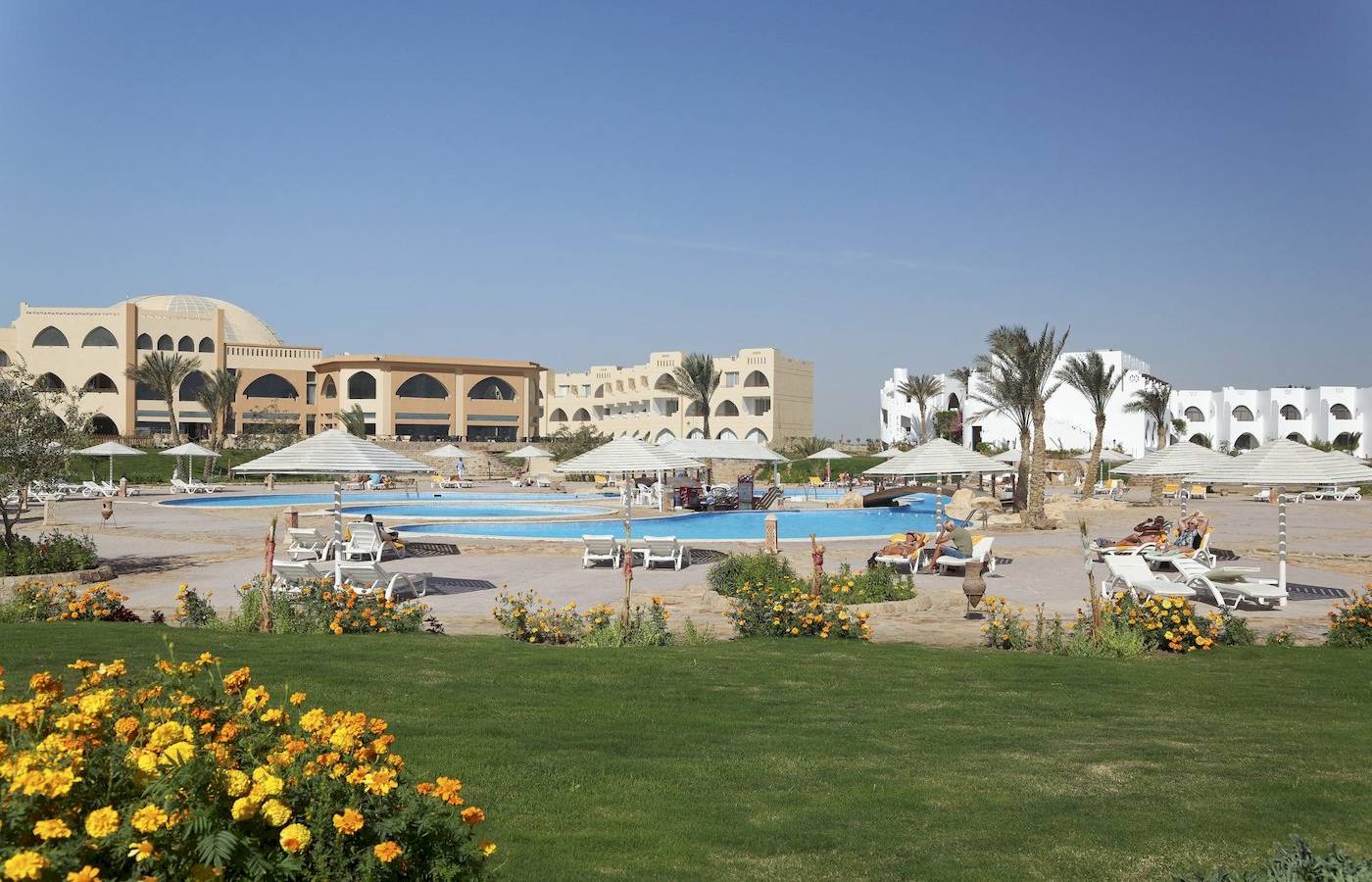 Außenbereich des Three Corners Equinox Beach Resorts mit Pool und Liegestühlen