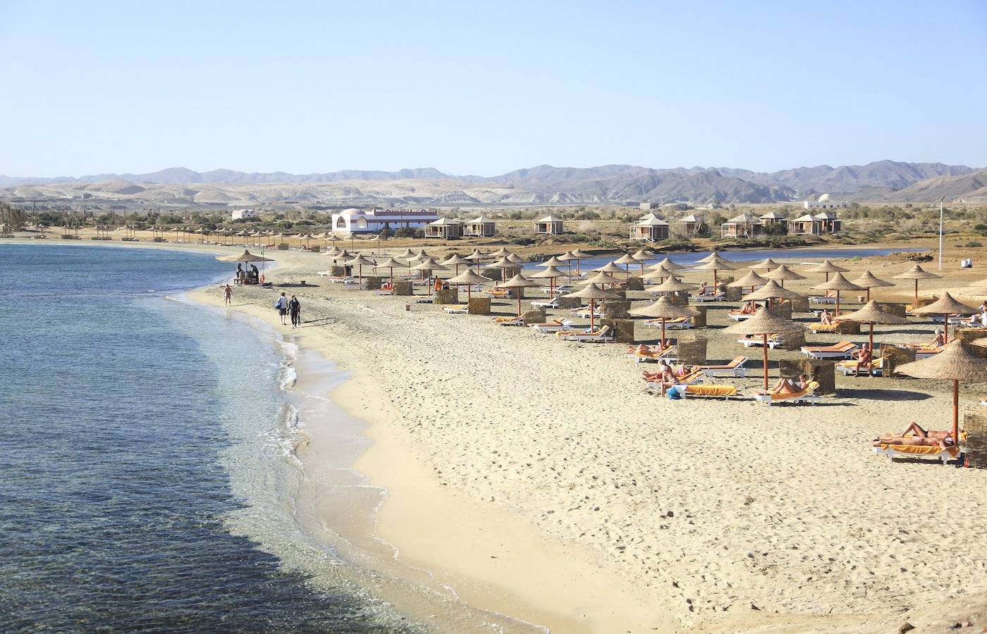 Strand des Three Corners Equinox Beach Resorts mit vielen Sonnenschirmen und Liegen.