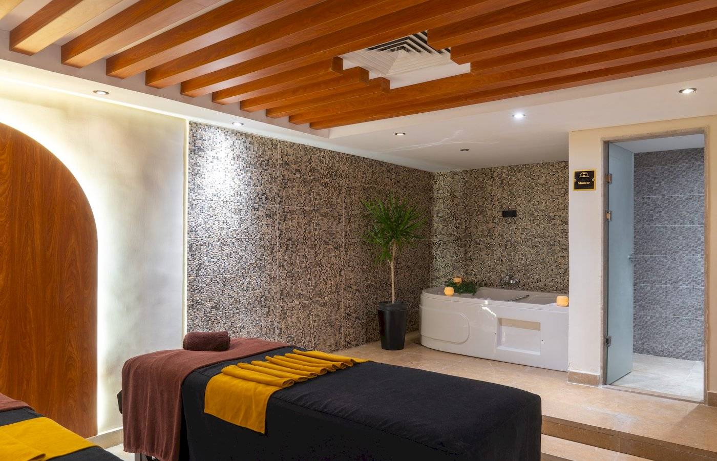 Massagebereich im Three Corners Happy Life Beach Resort mit zwei Massagebetten und einem Whirlpool.