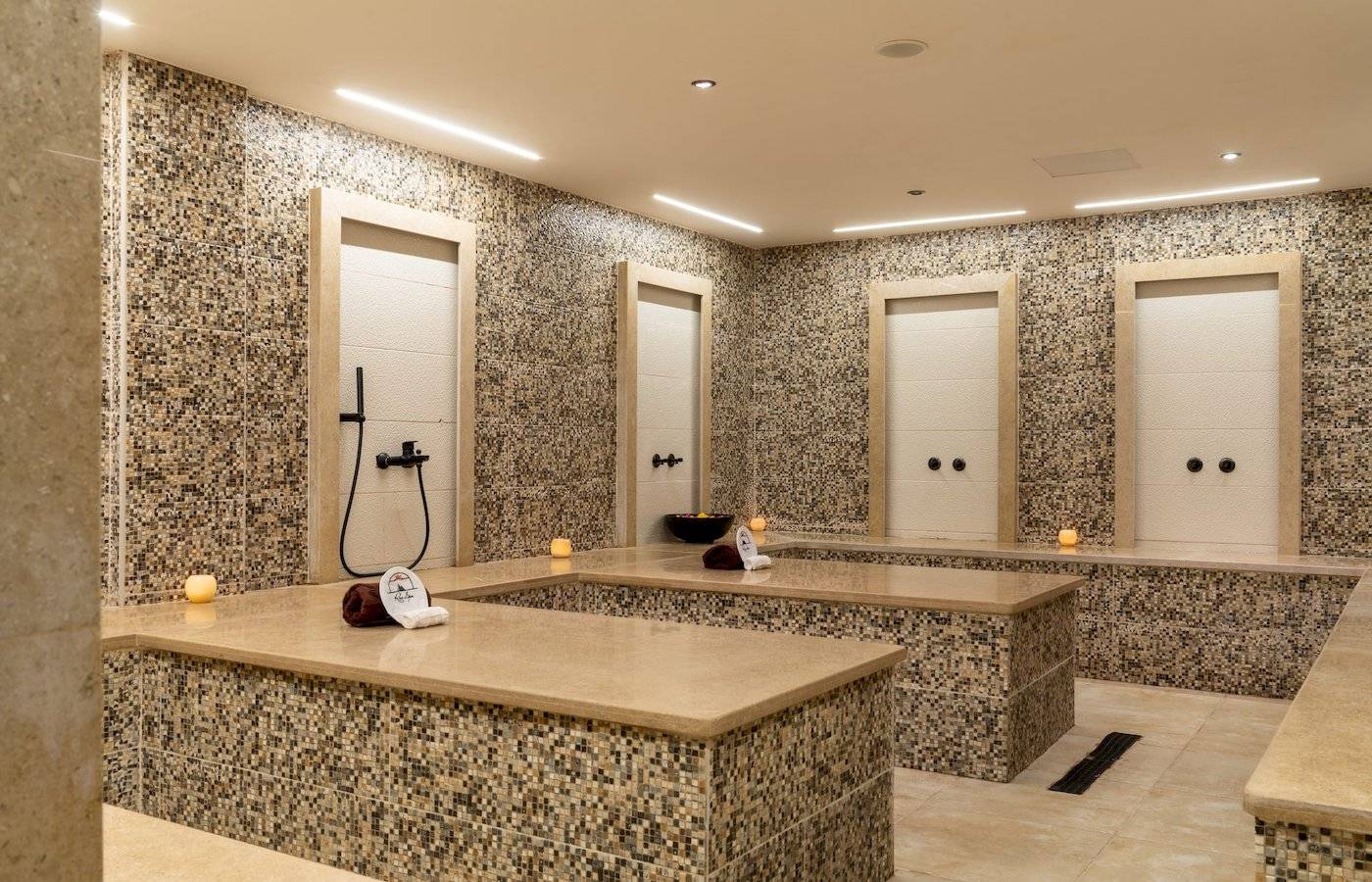 Wellnessbereich im Three Corners Happy Life Beach Resort mit mehreren begehbaren Whirlpools und beleuchteten Wänden.