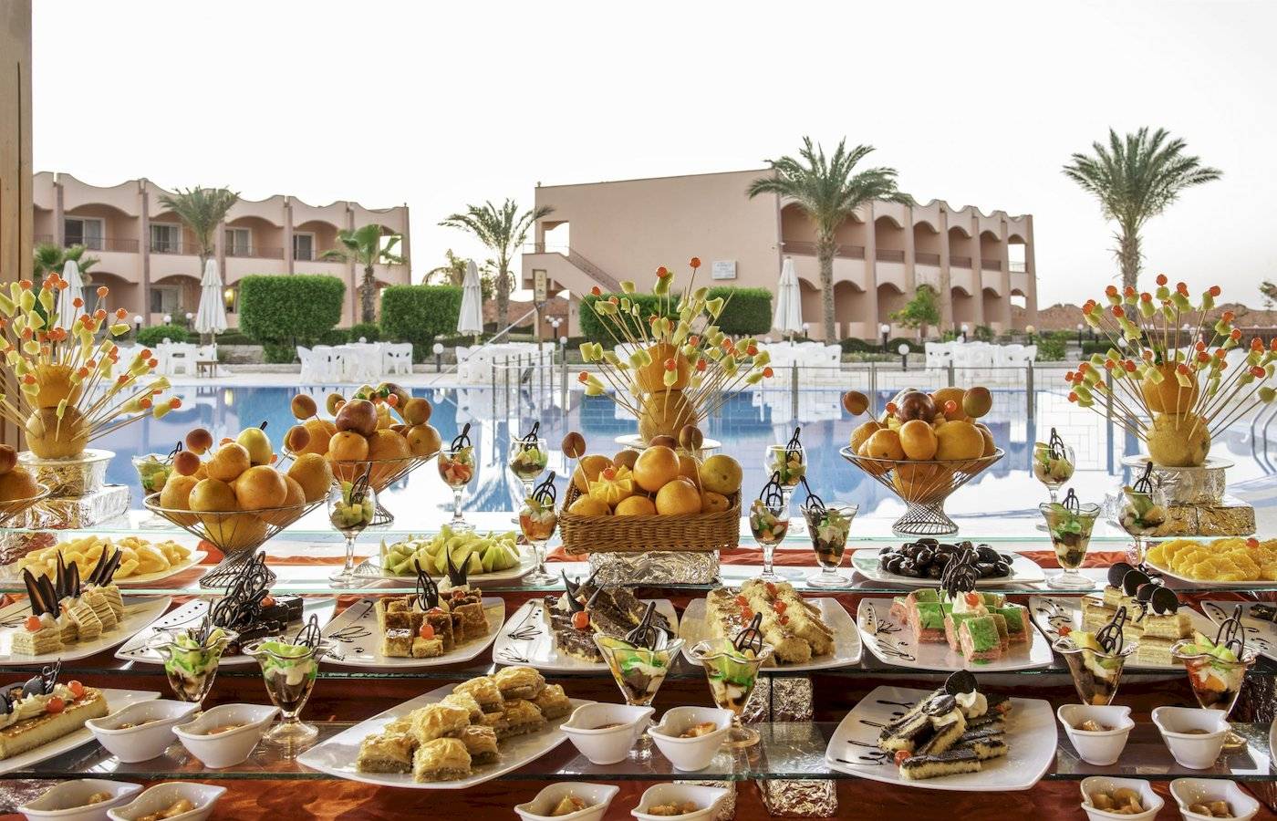 Poolseitiges Buffet mit einer Auswahl an Desserts im Three Corners Happy Life Beach Resort.