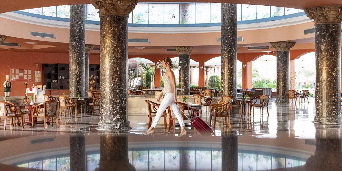 Frau mit Gepäck im Hotel-Foyer des Three Corners Happy Life Beach Resort