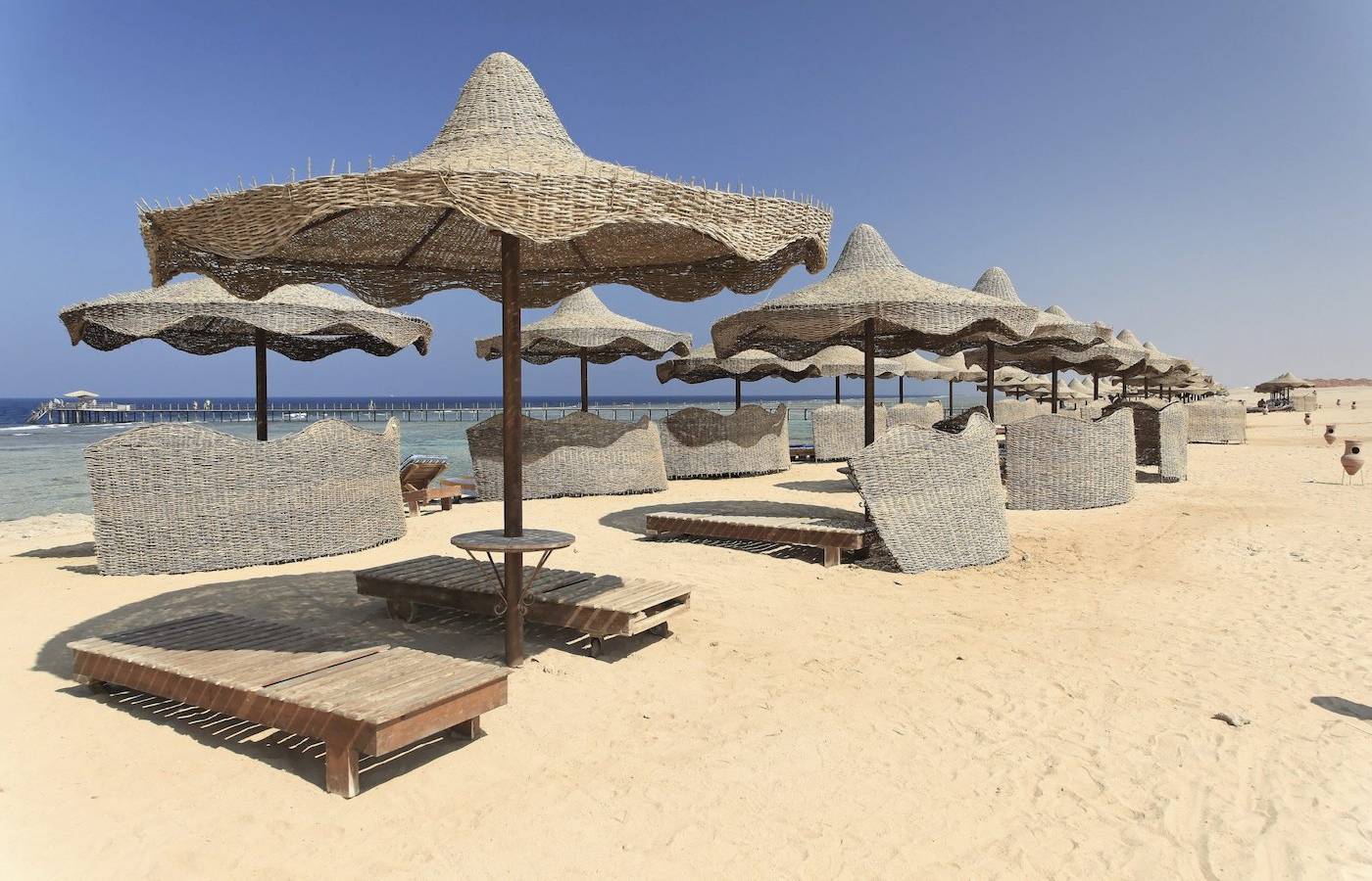 Strand mit Sonnenschirmen und Liegen im Three Corners Happy Life Beach Resort.