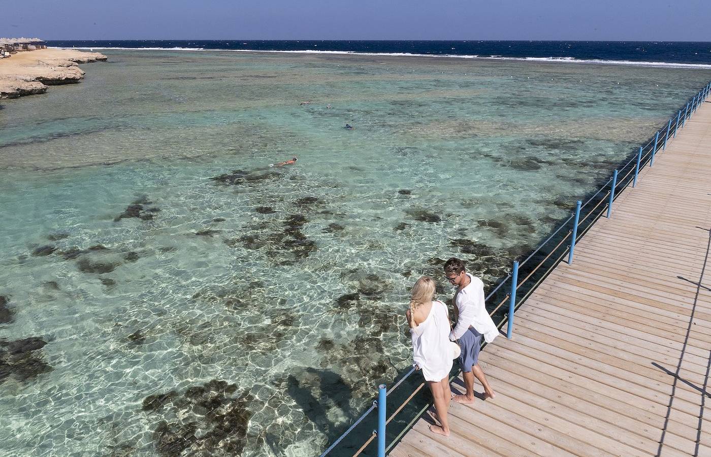 Aussicht auf das Drei Ecken Glückliches Leben Strand Resort mit zwei Personen auf einem Steg.
