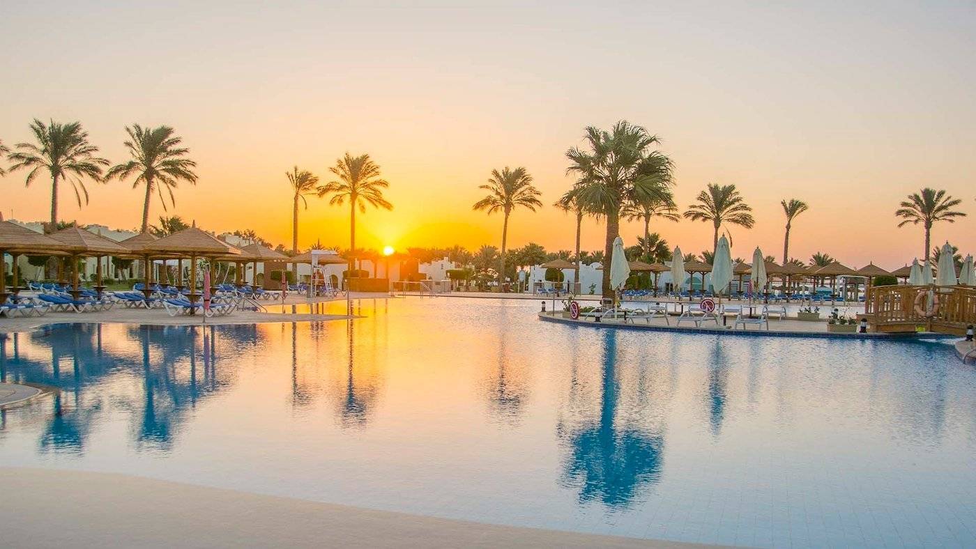 Sonnenuntergang im Sunrise Royal Makadi Resort mit Pool und Sonnenschirmen