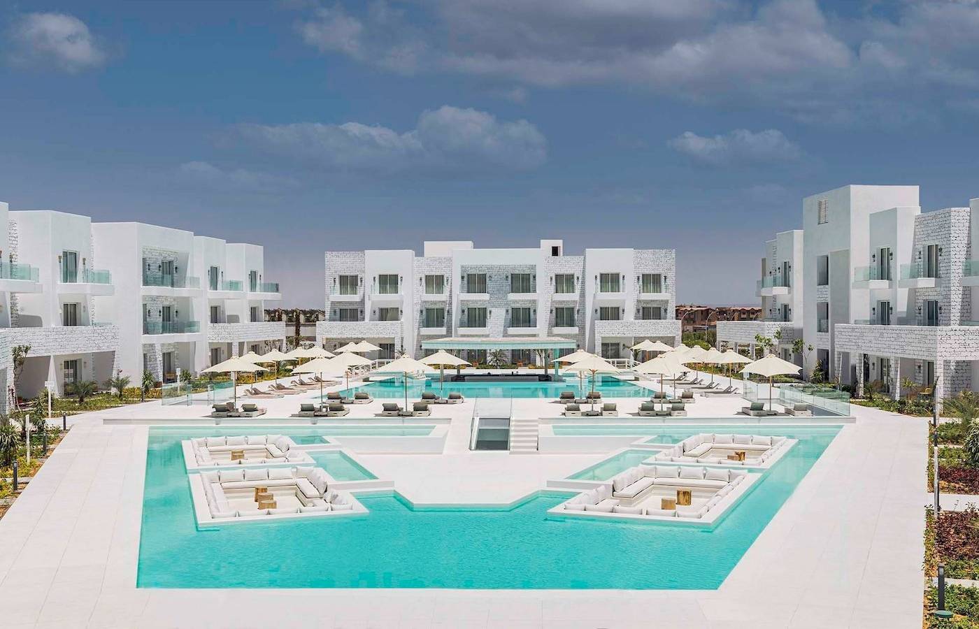 Außenbereich des Sunrise Royal Makadi Resort mit Swimmingpool und weißen Gebäuden.