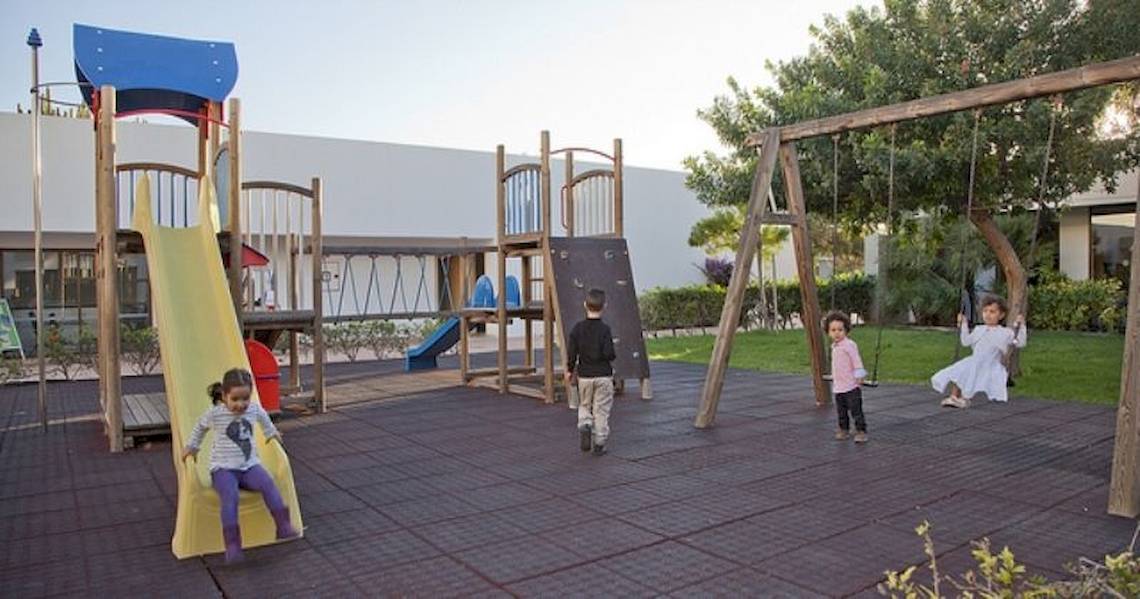 Kinder spielen auf einem Spielplatz im Freien im Costa Calero Thalasso & Spa Hotel.