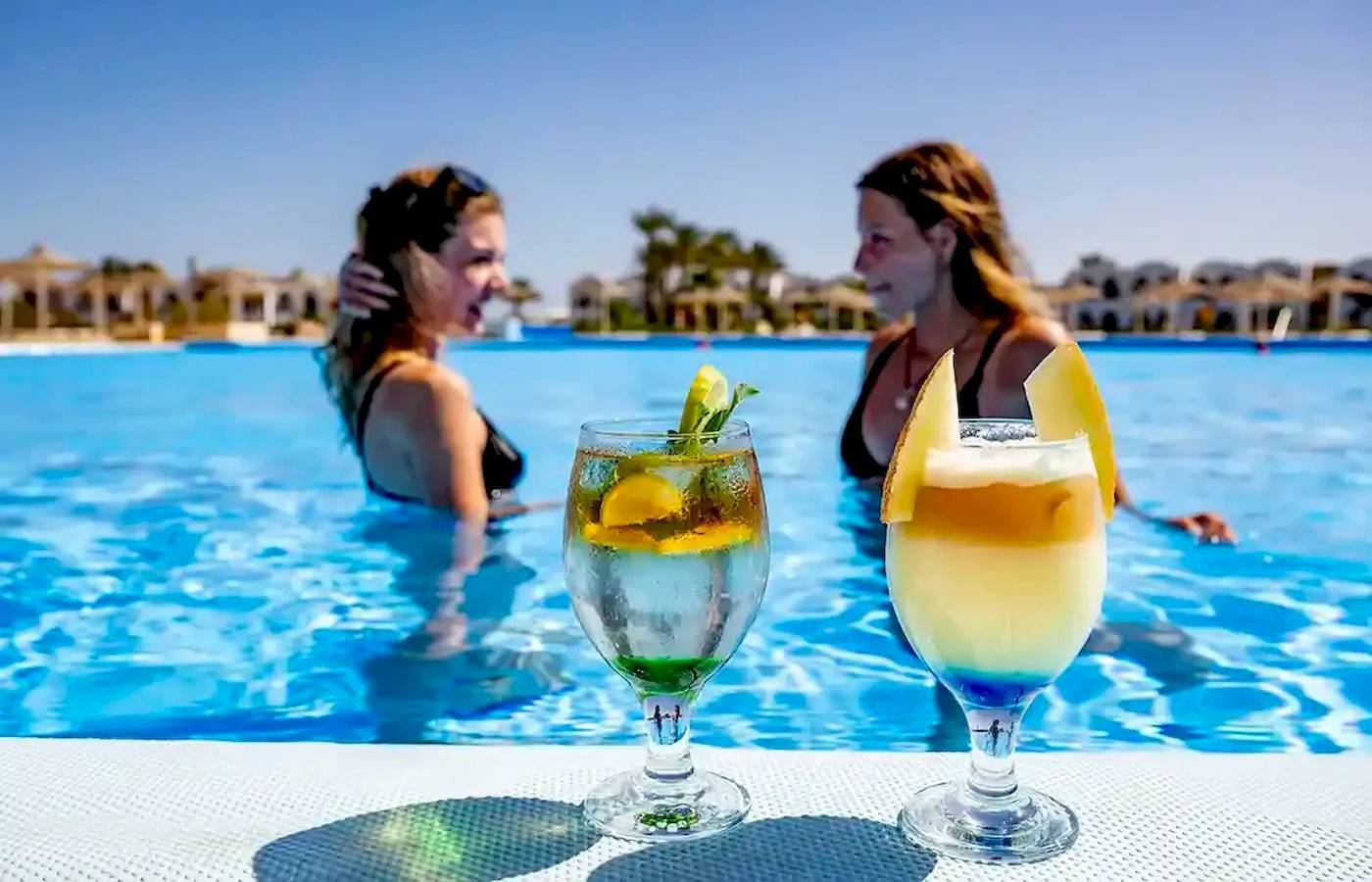 Zwei Frauen im Schwimmbad mit Getränkegläsern