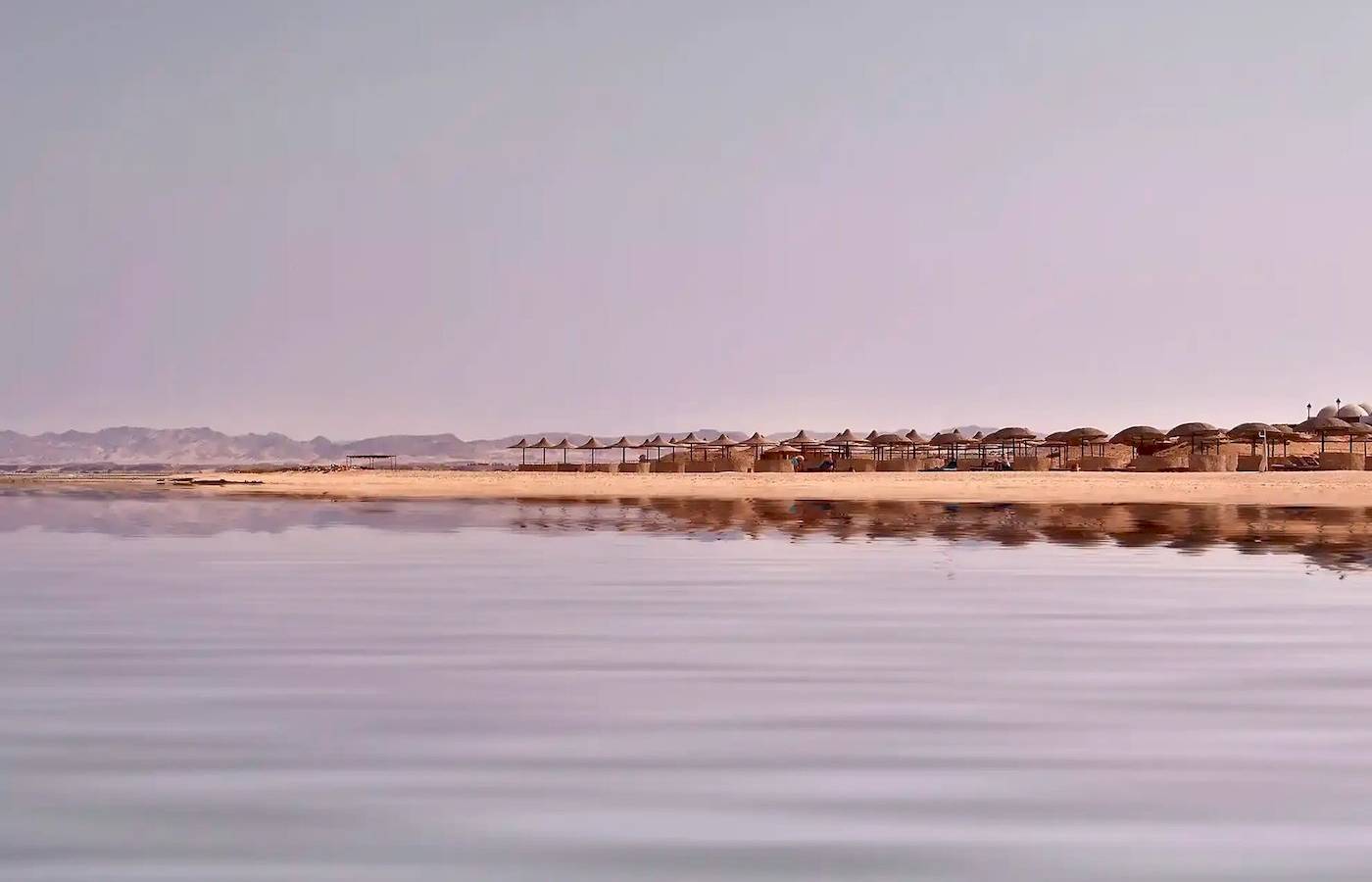 Strand des Gorgonia Beach Resorts mit vielen Sonnenschirmen am Horizont
