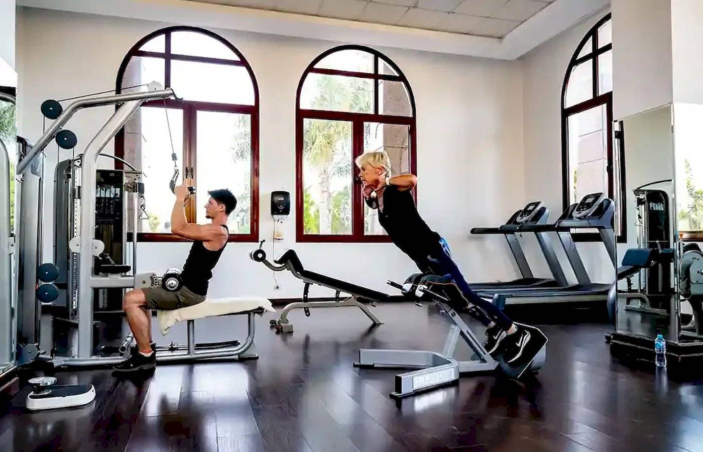 Fitness-Training im Gorgonia Beach Resort-Hotel-Gym mit zwei Personen, die verschiedene Geräte nutzen.