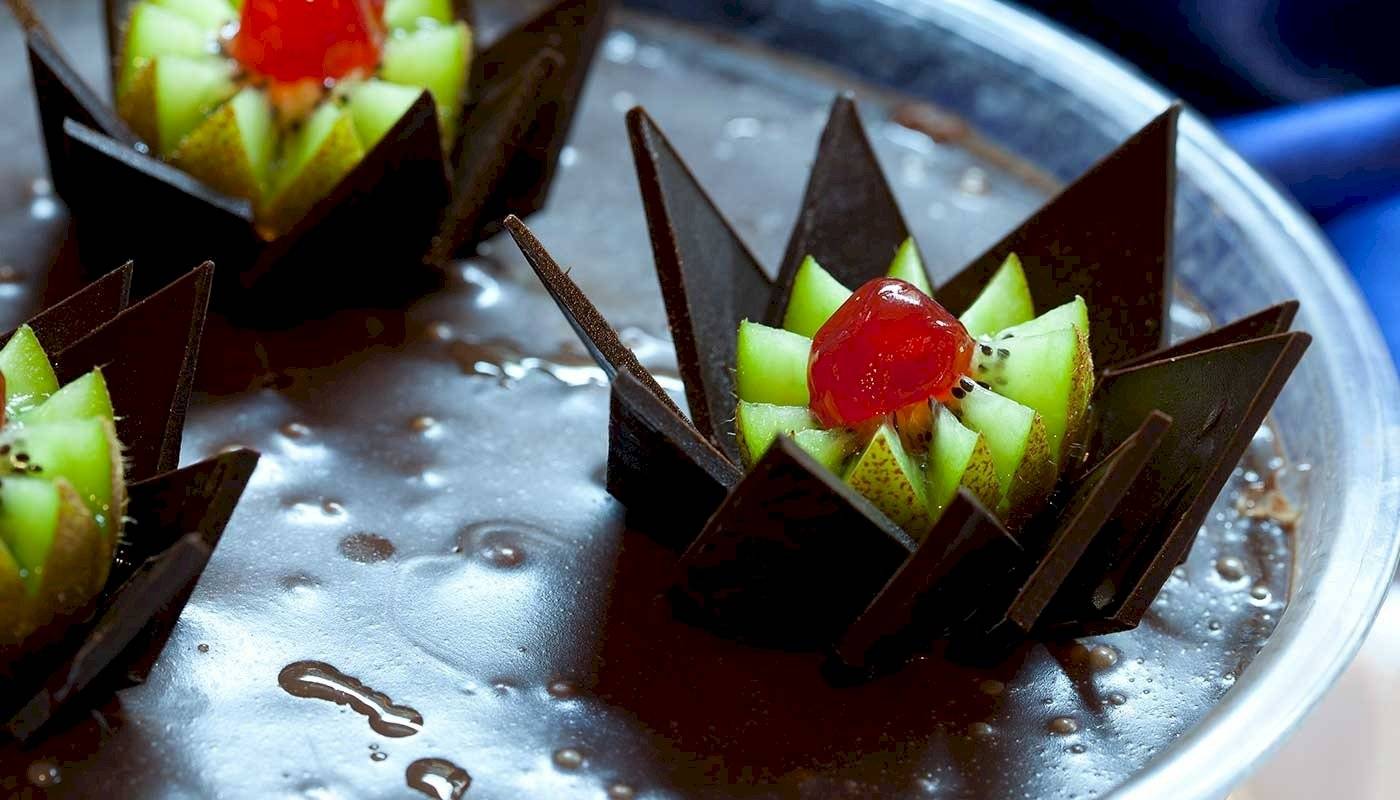 Schokoladen-Frucht-Dessert mit Kiwi und Kirsche auf einem Teller