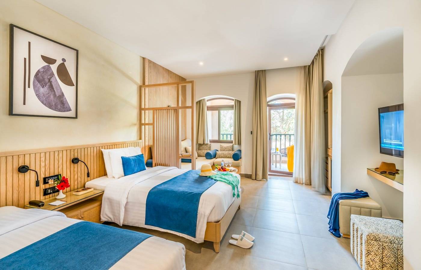 Doppelzimmer im Three Corners Rihana Resort mit zwei Betten, Balkon und Fernseher.