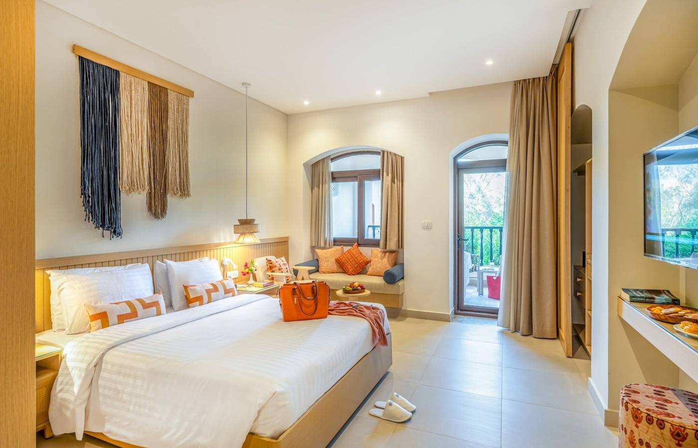 Drei-Ecken-Rihana-Resort-Zimmer mit großem Bett, Balkon und modernem Interieur.