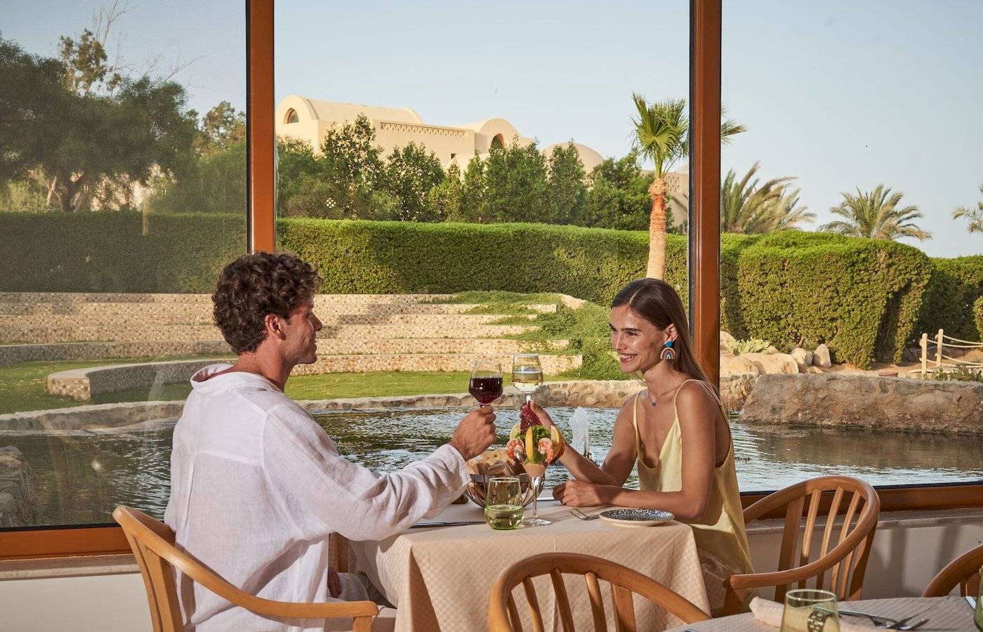 Paar genießt Mahlzeit mit Blick auf Hotelpool im Three Corners Rihana Resort