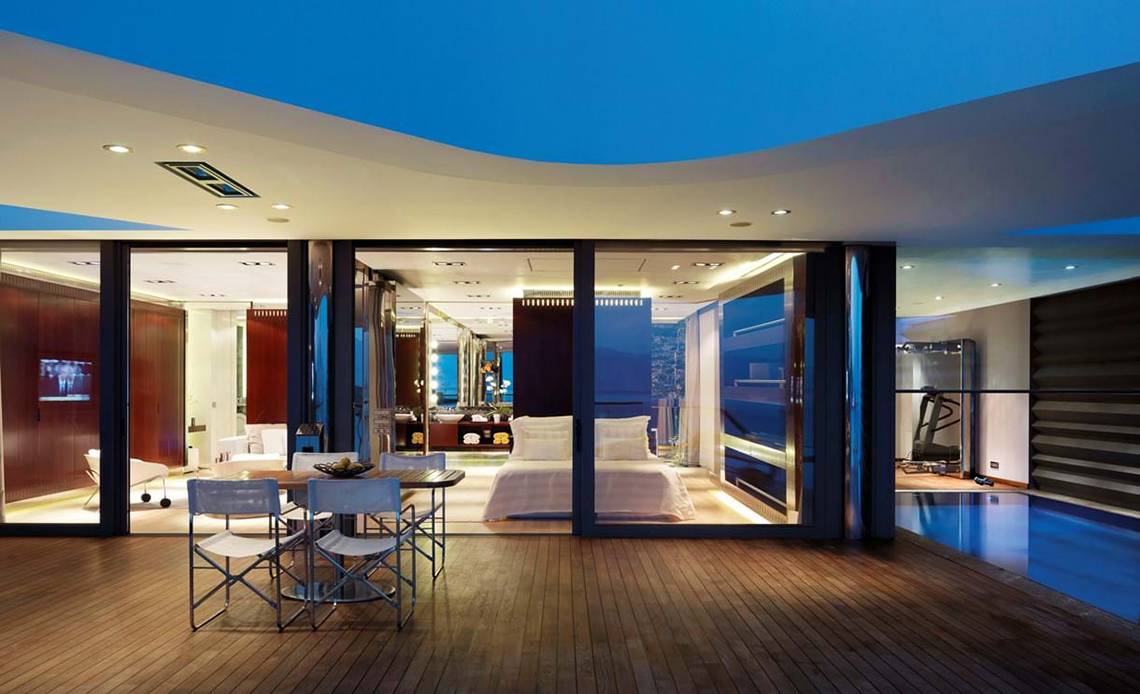 Innenansicht der Suite im Elounda Beach Hotel & Villas mit Esstisch und Blick auf das Bett.