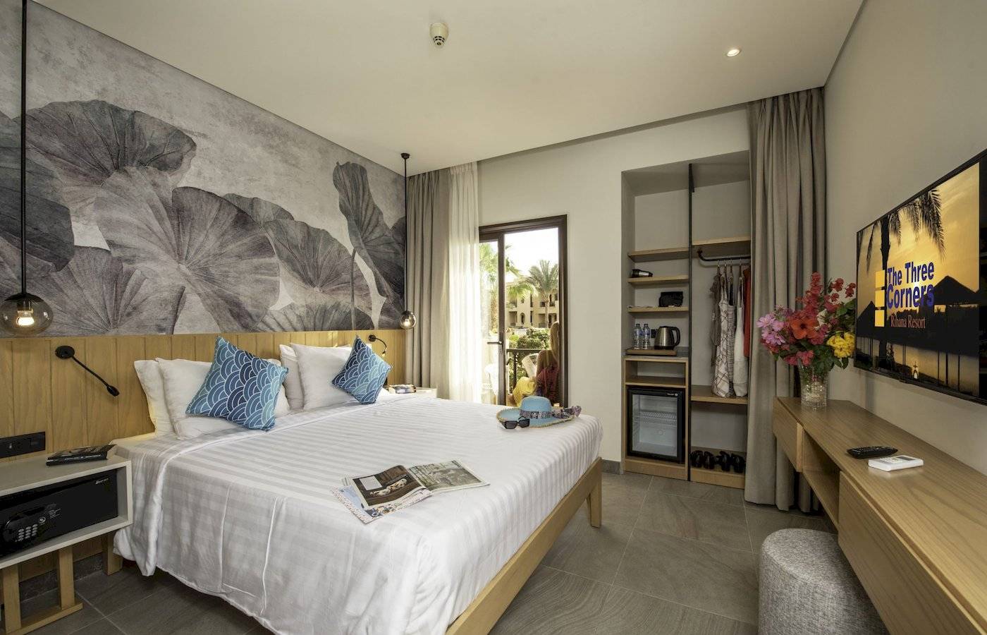Hotelzimmer im Three Corners Rihana Resort mit Bett, Deko und Fernseher.