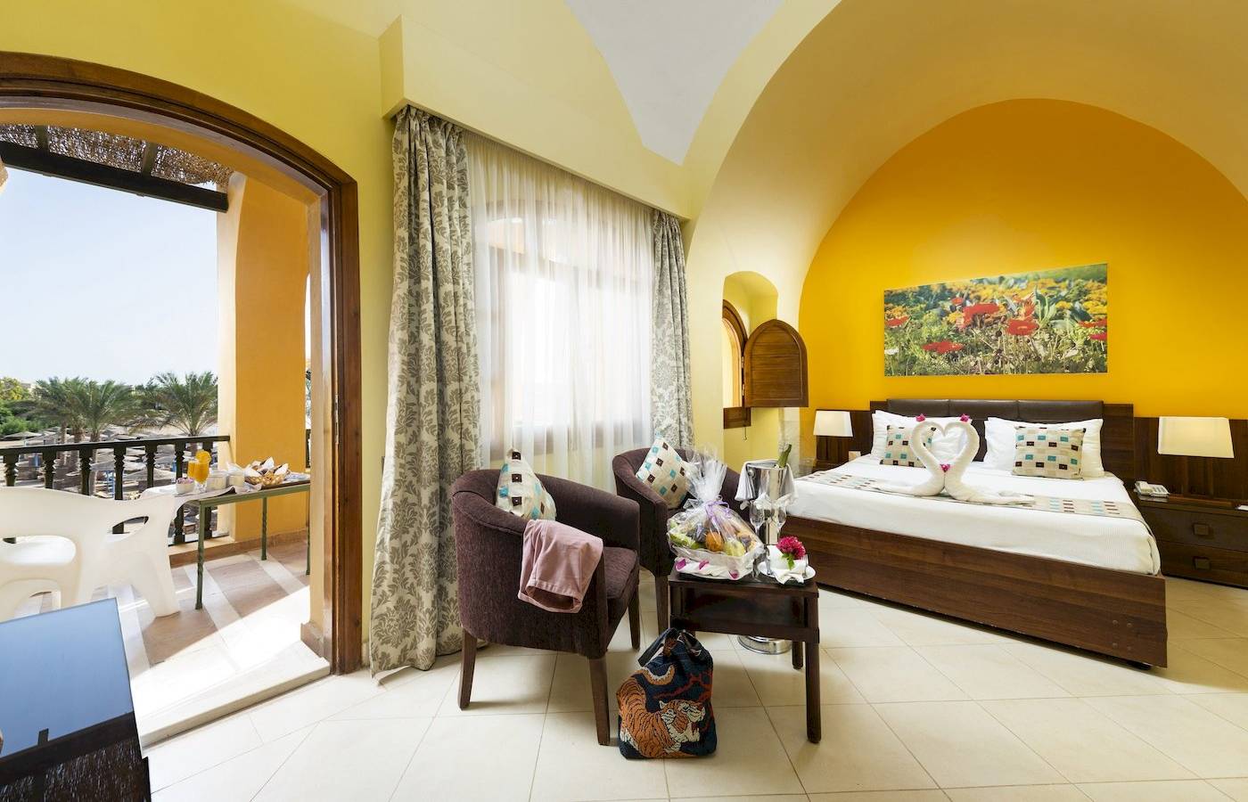 Innenansicht eines Hotelzimmers im Three Corners Rihana Resort mit Bett, Sesseln und Balkon