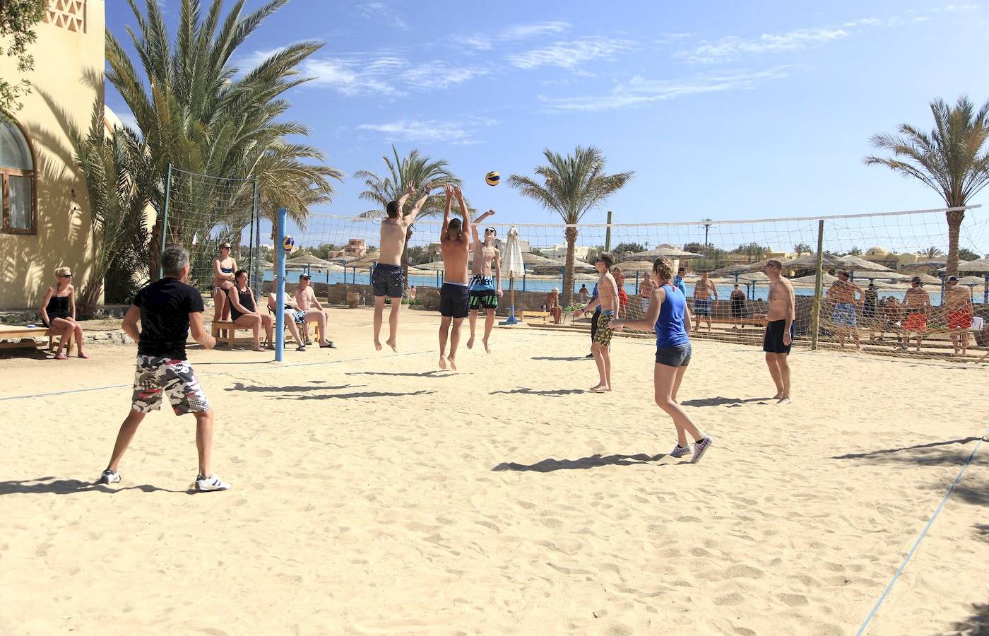 Gruppe junger leute spielt beach volleyball im dreiecks-rihana-resort
